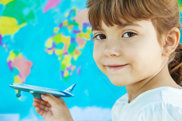 The plane is in the hands of the child. Selective focus.