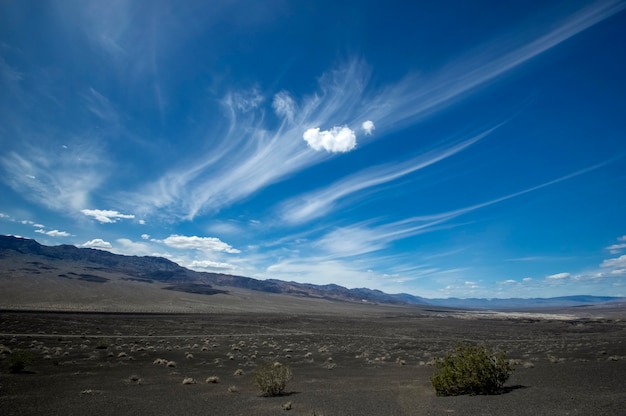 plane penetrating flawless cirrus clouds in a sparkle blue sky. Death valley, California. USA