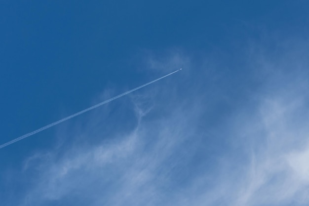 空の飛行機は白い道を残します雲のある美しい空旅行の夢