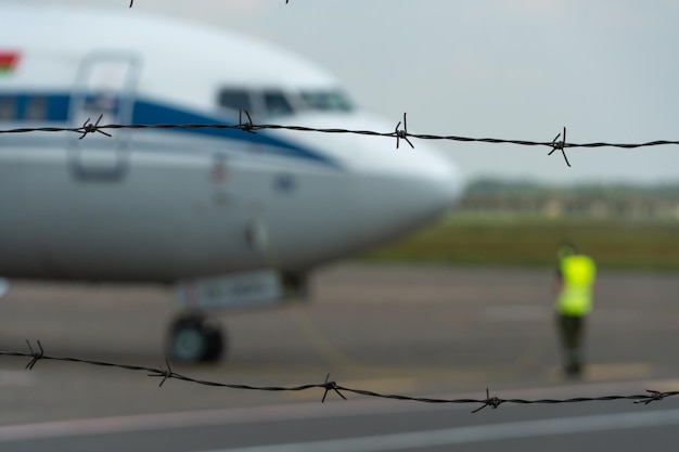 A plane on the territory of the airport against the background of barbed wire Closed territory of a private airfield Emergency landing of the aircraft The plane is on the runway