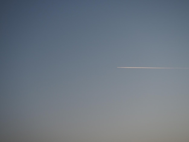 Plane and trail in the evening sky blue Abstract background on a space or aero theme Color gradient