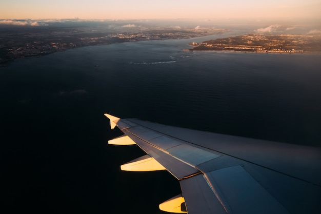 Photo plane wing above water in sunlight before landing