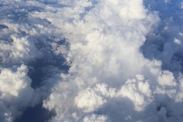 Крыло самолета в небе с красивыми голубыми облаками сбоку от окна