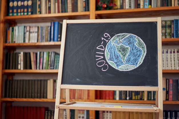 Planet Earth in danger Outbreak Warning. written white chalk on blackboard