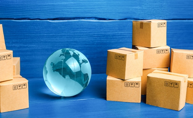 planet earth globe and cardboard boxes mass consumption products