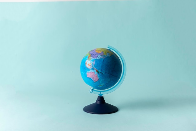 A planet earth school globe on pastel background concept of studying in school