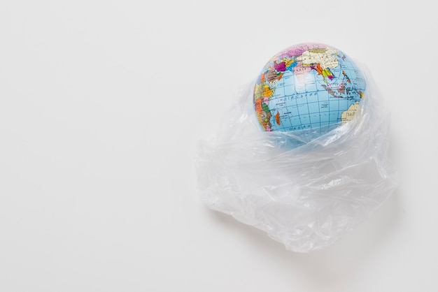 Planet in plastic bag on grey background
