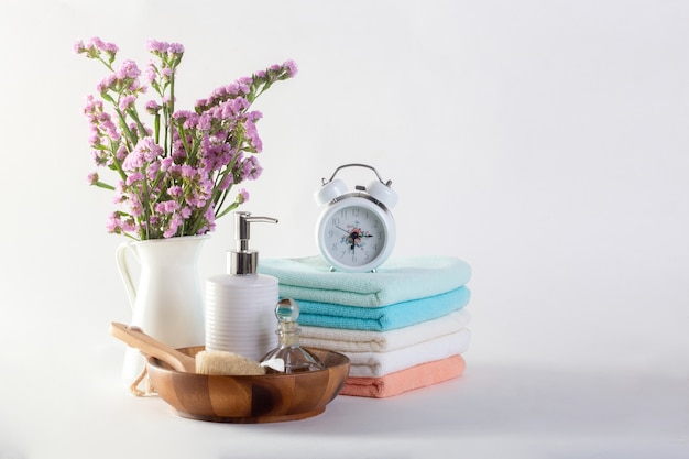 Plank met schone handdoeken, kaarsen, bloempot op badkamers witte achtergrond