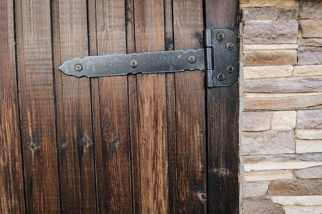 Planked varnished wooden door texture With heavy bar hinges