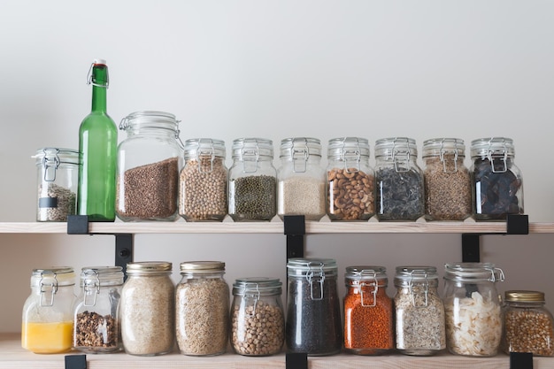 Planken met glazen potten gevuld met boodschappen