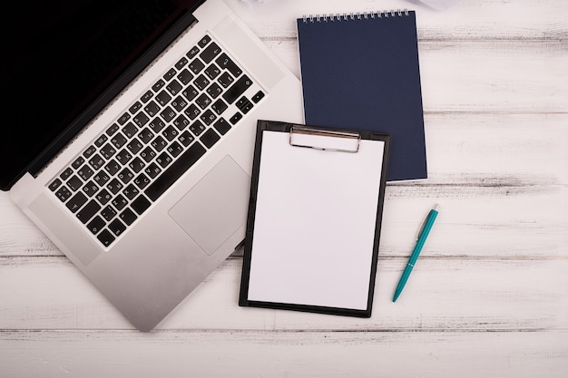 Planner on the wooden working table with computer blank white paper on working desk