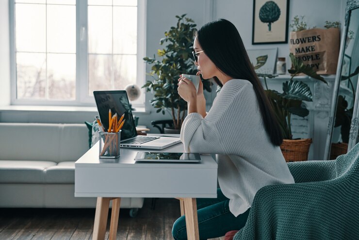 Photo planning another step. beautiful young woman working using computer while sitting in home office
