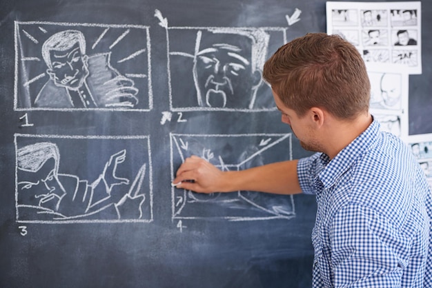 Planning for his next shoot A young man drawing up a storyboard on his office chalkboard