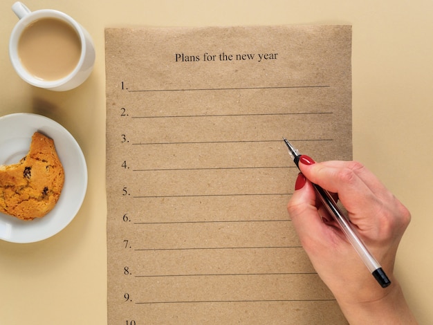 Plans for the new year. A black ballpoint pen in a woman's hand.