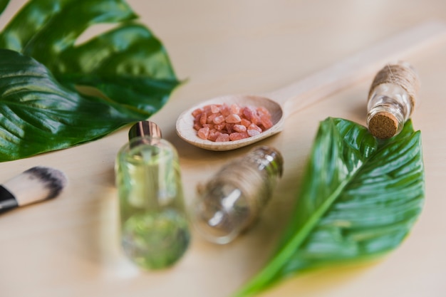 Plant leaves near essential oils and aroma salt