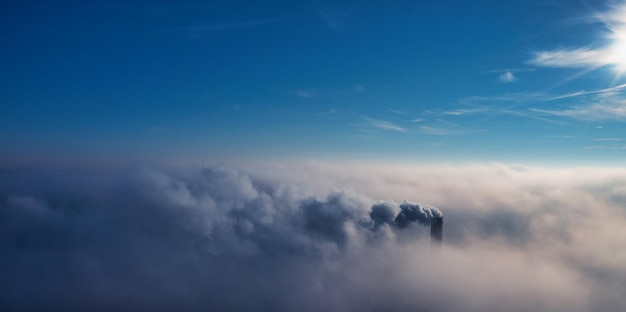 Труба завода высоко над облаками Вредные выбросы в верхние слои атмосферы