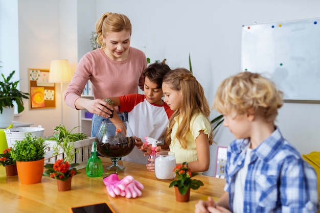 Plant science lesson. Blonde-haired teacher and her smart pupils having amazing plant science lesson