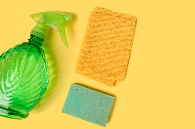 Plant sprayer sponge and rag. Home and housework. On a yellow background.