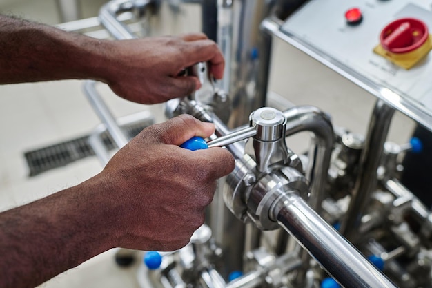 Plant worker turning levers on pipe