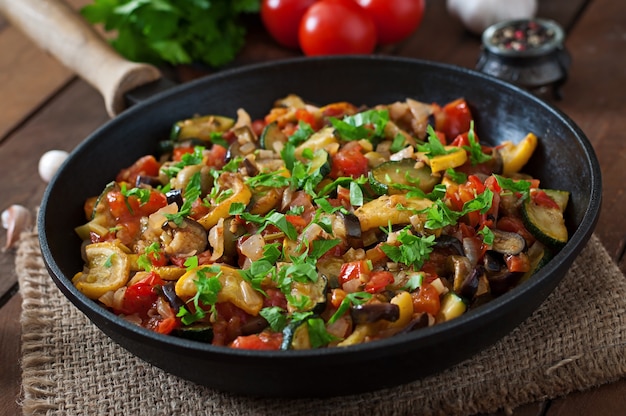 Plantaardige Ratatouille in pan op een houten tafel