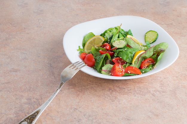 Plantaardige salade met groene groenten en kerstomaatjes in de plaat.