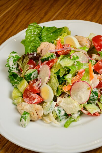 Plantaardige vegetarische salade met tomaten, paprika en uien op houten tafel. gezonde salade met verse rijpe zomergroenten