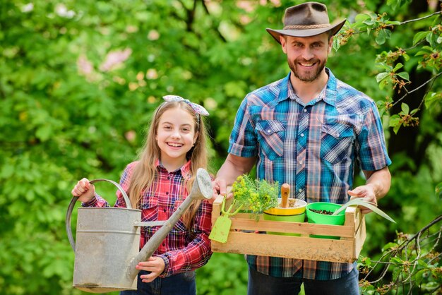 planting season family garden maintain garden planting flowers family dad and daughter planting plants transplanting vegetables from nursery or gardening center plant your favorite veggies