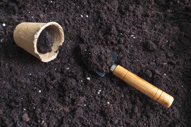 地面に春に種を植えます。泥炭ポットと地面の背景。春の植え付け作業。
