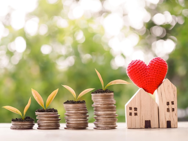 Photo plants growing up on stack of coins and miniature house the concept of saving money for house property investment house mortgage real estste