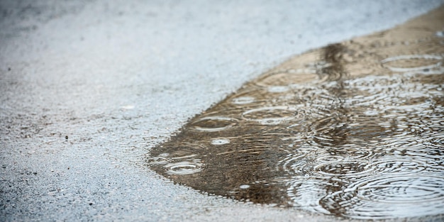 Plas op het asfalt in de regen