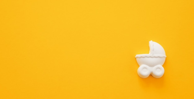 A plaster figure of a baby carriage on a colored background