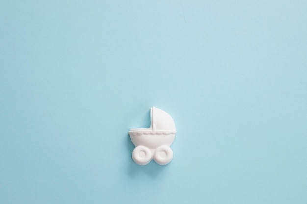 A plaster figure of a baby carriage on a colored background