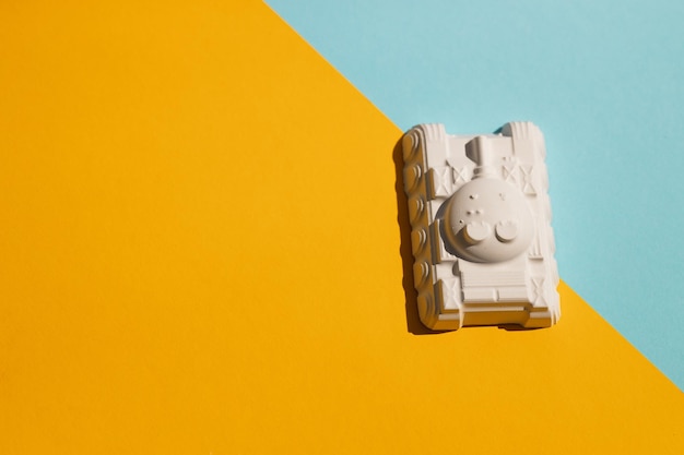 Plaster figure of a tank on a colored background