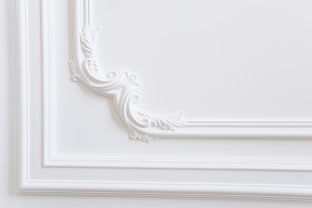 Photo plaster molding is a decorative decoration of a white wall in a classic style