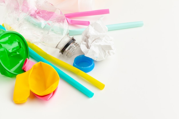 Plastic afval ecologie concept met afval en kleurrijke rietjes voor eenmalig gebruik, bestekbekers, flessen