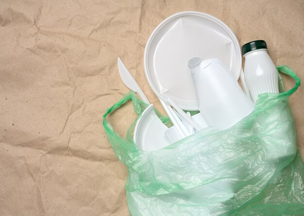 Plastic afval van het leven op bruin kraftpapier, milieuvervuiling, bovenaanzicht