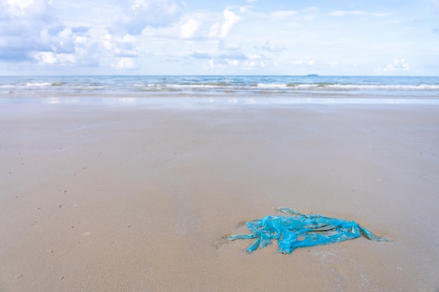 Plastic bag on sand beach, cleaning seaside beach. 