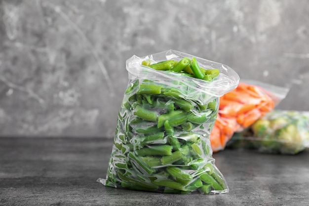 Plastic bag with frozen green beans on table Vegetable preservation