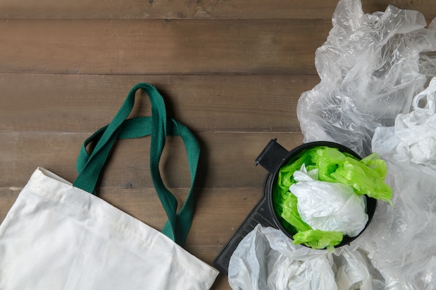 Photo plastic bags in bin and canvas tote bag on wood