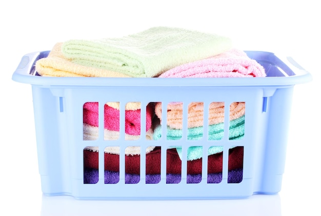 Plastic basket with bright towels isolated on white