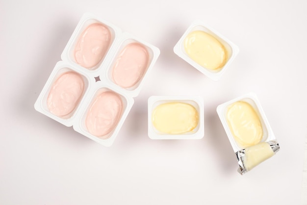 Plastic beker met lekkere yoghurt geïsoleerd op wit Bovenaanzicht Ruimte voor tekst of ontwerp