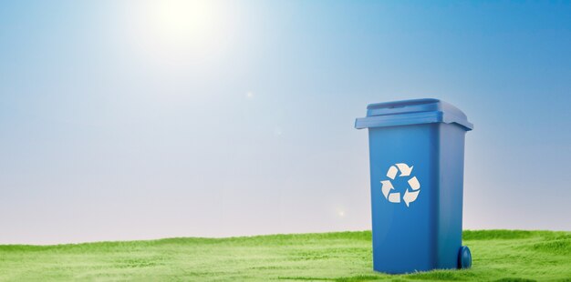 A plastic blue container stands on green grass against blue sky