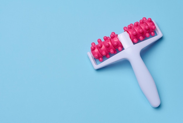 A plastic body massager on a blue background top view Body care