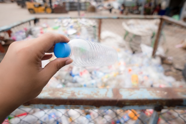 Plastic bottle on hand into bin for recycle