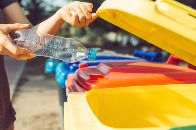 A plastic bottle is disposed of in a trash can