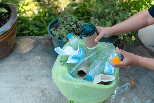재활용을 위한 플라스틱 병 폐기물 재활용 개념 자원봉사자들은 공원에서 카드보드 상자에 플라스티크 병을 보관합니다.