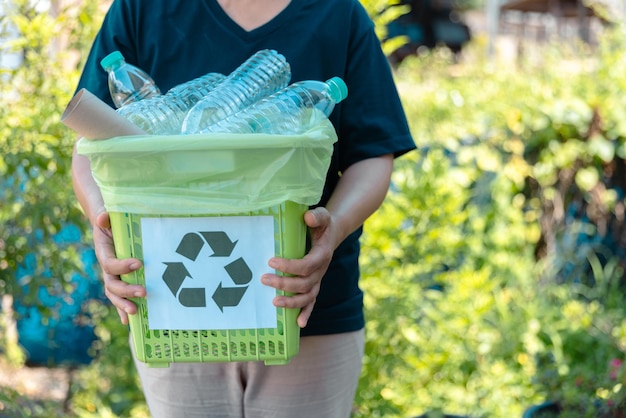 プラスチックボトルの廃棄物をリサイクルするための再利用コンセプト ボランティアが公園でプラスティックボトルを紙箱に保管する リサイクルと廃棄物管理 良心の良い