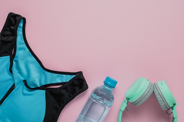 Plastic bottle with water and headphones with sportswear