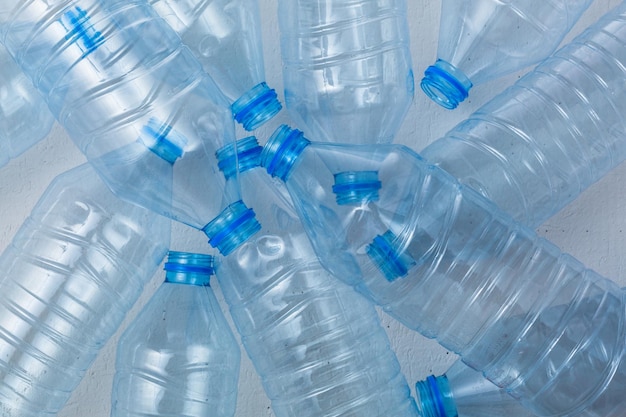 Photo plastic bottles on a blue background as a symbol of ecological catastrophes