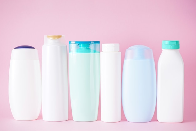 Plastic bottles for body care and cosmetics on yellow background.